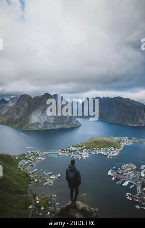 Norvège, îles Lofoten, Reine, Homme regardant le fjord de la montagne de Reinebringen Banque D'Images