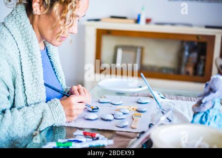 Femme peint des pierres à la maison Banque D'Images