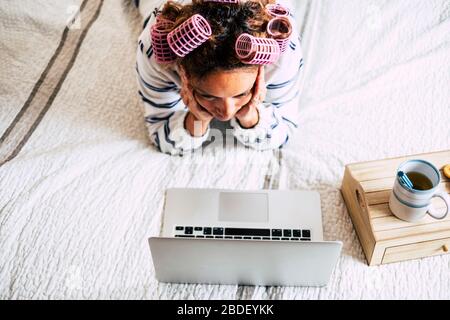 Femme avec des pillards couchés sur le lit et regardant ordinateur portable Banque D'Images