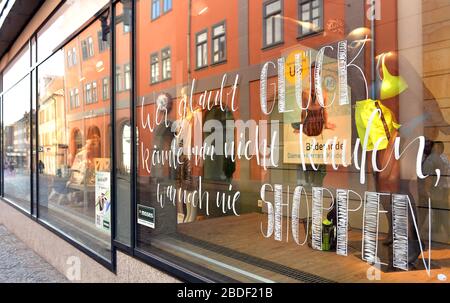 Gotha, Allemagne. 08 avril 2020. "Si vous pensez que vous ne pouvez pas acheter le bonheur, vous n'avez jamais fait du shopping" est écrit sur une fenêtre de magasin dans le centre-ville presque déserté. Pendant la crise de Corona, de nombreux détaillants, propriétaires de magasins, opérateurs de restaurants et artisans ont trouvé des moyens créatifs de continuer à être là pour leurs clients malgré la fermeture. Crédit: Martin Schutt/dpa-Zentralbild/dpa/Alay Live News Banque D'Images