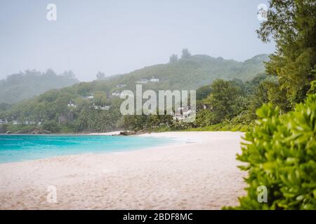 Pluie tropicale sur la plage d'anse intendance sur l'île de Mahe aux Seychelles Banque D'Images