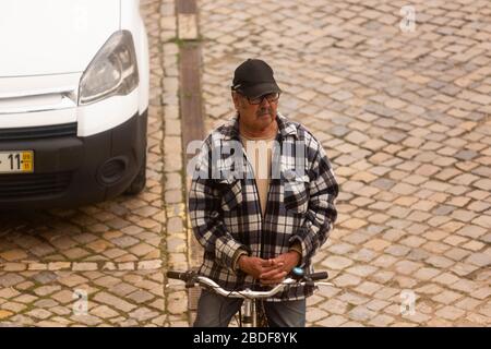 Olhão, Portugal, 8 avril 2020. Un homme priant devant l'église, avec les rues pratiquement désertes, à la suite de l'éclosion du Coro Banque D'Images