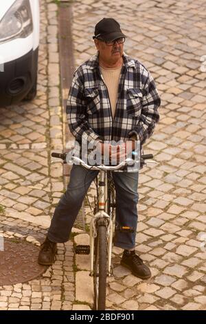 Olhão, Portugal, 8 avril 2020. Un homme priant devant l'église, avec les rues pratiquement désertes, à la suite de l'éclosion du Coro Banque D'Images