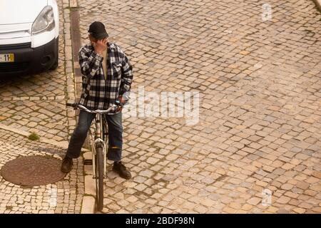 Olhão, Portugal, 8 avril 2020. Un homme priant devant l'église, avec les rues pratiquement désertes, à la suite de l'éclosion du Coro Banque D'Images