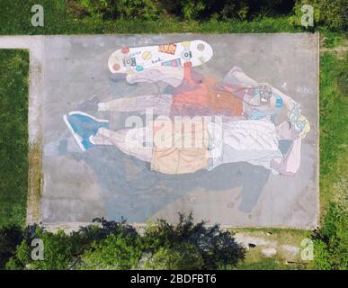 Drone image de terrain de jeu peint en couple allongé sur leur dos et regarder le ciel Banque D'Images