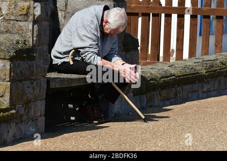 Weston-Super-Mare, Royaume-Uni. 08ème avril 2020.verrouillage de Covid 19. Monsieur âgé assis avec un bâton de marche crédit: Robert Timoney/Alay Live News Banque D'Images