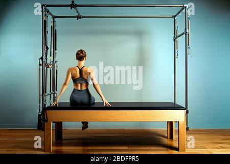 l'entraînement de leotard pilote l'entraînement. exercices de remantage de pilotes sportifs. équipement de machine de pilates. jeune femme pilote le sport d'étirement dans le lit de remantage Banque D'Images