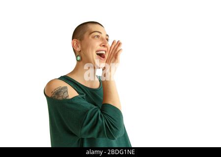 Appel, crier. Portrait de la jeune femme caucasienne avec une apparence freaky sur fond blanc. Look inhabituel avec tatouages et chauve. Émotions humaines, expression faciale, ventes, concept publicitaire. Culture de la jeunesse. Banque D'Images