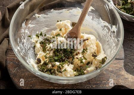 Beurre et jeunes bouillettes hachées dans un bol - ingrédients pour préparer du beurre aux herbes Banque D'Images