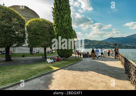 Côme, ITALIE - 4 août 2019: Les gens du coin et les touristes sur la promenade le long du lac dans le centre de la belle ville italienne de Côme. Chaud soleil sume Banque D'Images