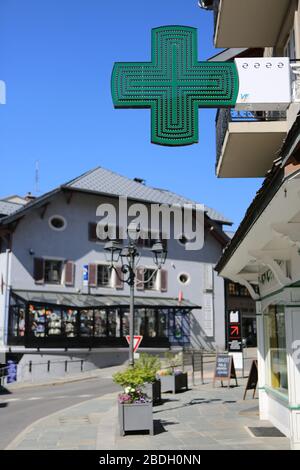 Enligne de pharmacie. Panneau vert en forme de croix. Centre-ville. Saint-Gervais-les-bains. Haute-Savoie. France. Banque D'Images