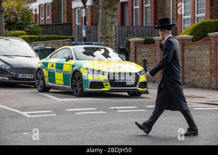 Juif ultra-orthodoxe dans la communauté juive de Stamford Hill en passant une ambulance devant les célébrations de la Pâque pendant le COVID-19, a verrouillé le Royaume-Uni Banque D'Images