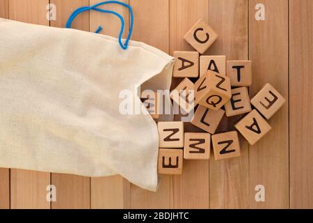 Sac en tissu et cubes en bois vue de dessus. Cubes en bois avec lettres de l'alphabet anglais, jeux éducatifs pour enfants. Sacs en lin pour le stockage de jouets an Banque D'Images