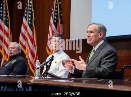 Le gouverneur du Texas, Greg Abbott, à droite, a remis en mémoire le corps de presse du Capitole sur les entreprises du Texas qui ont fait monter la production volontaire de masques et de masques faciaux pour répondre à la demande croissante dans la lutte contre l'épidémie de coronavirus. Directeur d'État de la gestion des urgences NIM Kidd, centre, écoute. Banque D'Images