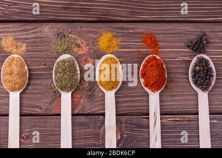 Assortiment d'épices colorées dans l'cuillères en bois. Banque D'Images