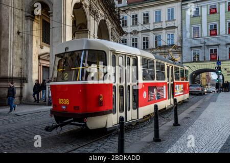 Le vieux tramway rouge passe par l'église Saint-Salvator de la vieille ville de Prague Banque D'Images