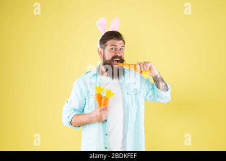 La carotte est composée de vitamines. Heureux et sain. Lapin de Pâques, retenir les carottes. Les oreilles de lapin d'homme barbu contiennent des légumes. Une alimentation saine. Régime végétarien. Pâques en bonne santé. Faits nutritionnels et avantages pour la santé. Banque D'Images