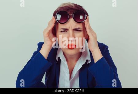 Headshot sérieuse femme en colère bas tenant des lunettes de soleil vers le haut sceptique regardant vous isolé mur vert fond bleu costume blanc chemise. Humain Banque D'Images