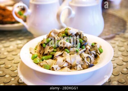 La cuisine végétarienne chinoise populaire, composée de fèves sautées avec des bandes de tofu et du chou de neige pickled, est très appréciée. Banque D'Images