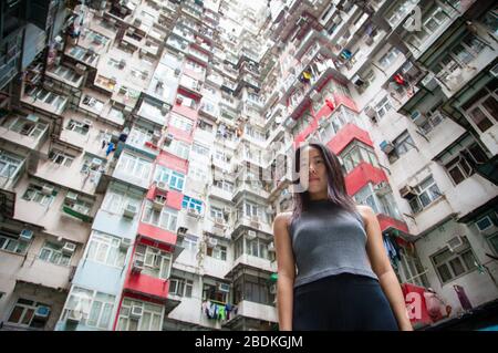 Une jeune fille chinoise explorant le paysage urbain des quartiers de logements publics crammés de Hong Kong à Quarry Bay, sur l'île de Hong Kong Banque D'Images