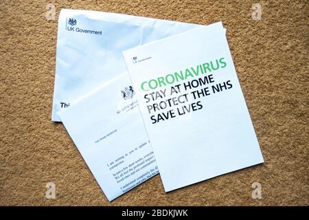 Lettre et dossier d'information envoyés par le gouvernement britannique aux ménages britanniques en avril 2020, donnant des instructions pour suivre et détailler les conseils sur l'évitement de la passation de marché du coronavirus. Banque D'Images