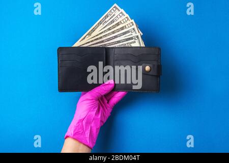 Les gants en caoutchouc contiennent une toux avec de l'argent. Argent américain. Le concept de la crise financière mondiale. Aide financière à la médecine Banque D'Images