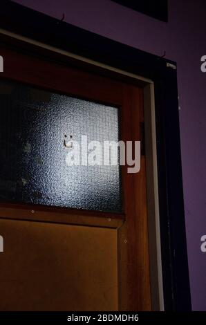 WELLINGTON, NOUVELLE-ZÉLANDE - 4 avril 2020: Visage souriant peint sur la fenêtre de porte Banque D'Images