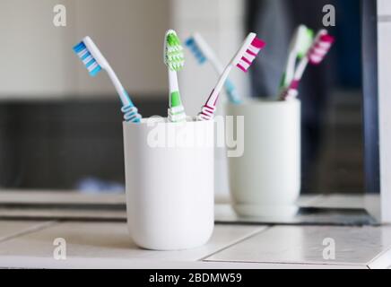 Berlin, Allemagne. 05 avril 2020. ILLUSTRATION - une tasse avec trois brosses à dents est placée dans une salle de bains et se reflète dans un miroir. Crédit: Wolfram Steinberg/dpa/Alay Live News Banque D'Images