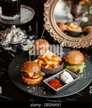 mini cheeseburgers et frites sur une plaque Banque D'Images