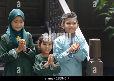 Les enfants musulmans se clactant les mains, Hari Raya Eid Al-Fitr concept. Banque D'Images