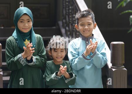 Les enfants musulmans se clactant les mains, Hari Raya Eid Al-Fitr concept. Banque D'Images