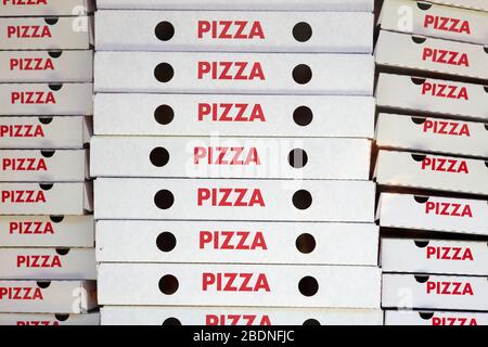 De nombreuses boîtes à pizza vides dans la fenêtre d'un service de livraison de pizza Banque D'Images