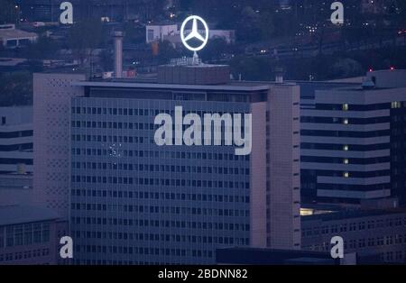 09 avril 2020, Bade-Wuerttemberg, Stuttgart: Aucune lumière ne brûle dans le bâtiment administratif principal de Daimler AG à Untertürkheim, l'étoile Mercedes brille sur le toit. Le constructeur automobile Daimler continue de lutter contre les effets massifs de la pandémie de coronavirus. Photo: Marijan Murat/dpa Banque D'Images