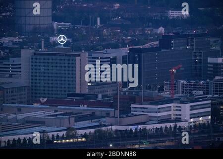 09 avril 2020, Bade-Wuerttemberg, Stuttgart: Seulement quelques lumières brûlent tôt le matin dans les bâtiments du siège social de Daimler AG à Untertürkheim, et la Mercedes Star brille sur le bâtiment administratif principal. Le constructeur automobile Daimler continue de lutter contre les effets massifs de la pandémie de coronavirus. Photo: Marijan Murat/dpa Banque D'Images