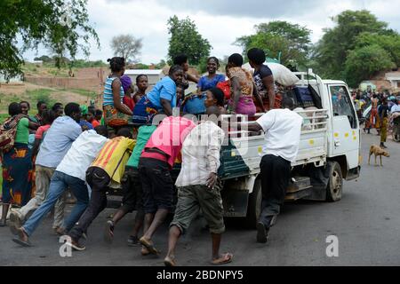 Zambie, Sinazongwe, marché rural dans le village, les hommes poussent un mini camion de panne surchargé de femmes groupe / SAMBIA, Sinazongwe Distrikt, laendlicher Markt an einer Strasse im Dorf Banque D'Images