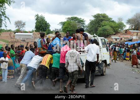 Zambie, Sinazongwe, marché rural dans le village, les hommes poussent un mini camion de panne surchargé de femmes groupe / SAMBIA, Sinazongwe Distrikt, laendlicher Markt an einer Strasse im Dorf Banque D'Images