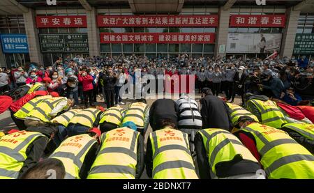 (200409) -- WUHAN, le 9 avril 2020 (Xinhua) -- les policiers, les employés de l'hôtel et les bénévoles qui ont fourni des services de soutien à l'équipe médicale Henan s'inclinent vers les mades qui partent à Wuhan, dans la province de Hubei en Chine centrale, le 19 mars 2020. (Xinhua/Fei Maohua) Banque D'Images