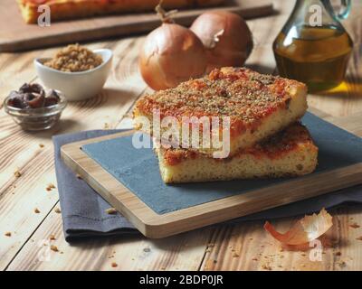 Pain italien traditionnel sicilien à pizza focaccia appelé sfincione, préparé avec des oignons, sauce tomate, anchois, fromage caciocavallo et miettes de pain Banque D'Images