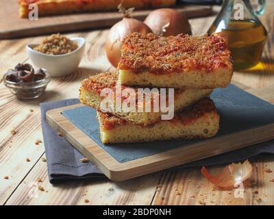 Pain italien traditionnel sicilien à pizza focaccia appelé sfincione, préparé avec des oignons, sauce tomate, anchois, fromage caciocavallo et miettes de pain Banque D'Images