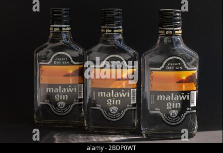 KIEV, UKRAINE - 03 AVRIL 2020: Trois bouteilles de verre de 200 ml de gin Malawi restant près l'une de l'autre sur un fond sombre. Un ressortissant malawian africain Banque D'Images