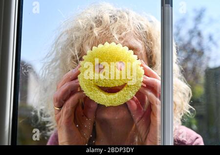 Femme nettoyant ses fenêtres à l'aide d'une éponge de nettoyage Scrub Daddy Banque D'Images