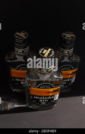 KIEV, UKRAINE - 03 AVRIL 2020: Photo verticale du haut de trois bouteilles de verre de 200 ml de gin Malawi restant l'une après l'autre sur un fond sombre Banque D'Images