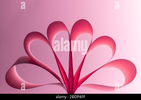 Forme abstraite en papier sur fond rose. Le motif géométrique des formes de coupe de papier. Amour, Saint-Valentin, fête des mères, cartes de vœux d'anniversaire, invita Banque D'Images