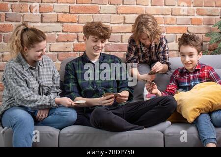 concept d'amitié, de communication et de personnes - un groupe de jeunes amis heureux se reposant à la maison, jouer à des jeux, parler, regarder la télévision Banque D'Images