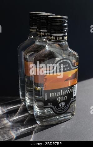 KIEV, UKRAINE - 03 AVRIL 2020: Photo verticale de trois bouteilles de verre de 200 ml de gin Malawi sous un angle spécial sur un fond sombre. Un national Banque D'Images