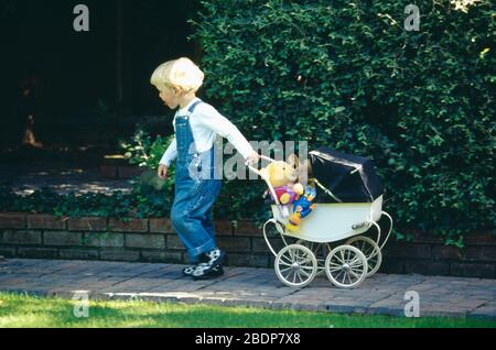 Petit enfant jouant dans un poram de jouet dans le jardin POUR USAGE ÉDITORIAL SEULEMENT À USAGE ÉDITORIAL. CONSULTEZ LE BUREAU POUR PLUS D'INFORMATIONS. USAGE ÉDITORIAL UNIQUEMENT. CHE Banque D'Images