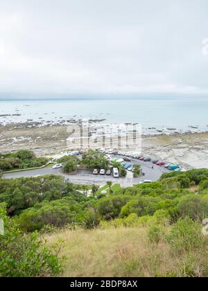 La côte rocheuse, la côte et le paysage de point Kean Kaikoura Nouvelle-Zélande en journée grise avec vue sur le parking. Banque D'Images