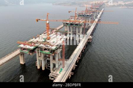 Zhengzhou. 9 avril 2020. La photo aérienne prise le 9 avril 2020 montre le chantier d'un pont de l'autoroute Mianchi-Yuanqu au-dessus de la rivière jaune, province du Henan au centre de la Chine. Le pont est une importante voie express interprovinciale reliant les provinces de Shanxi et de Henan, avec une longueur design de 1 757 mètres et une largeur de 33 mètres. Le projet devrait être achevé et ouvert au trafic d'ici la fin de 2020. Crédit: Zhu Xiang/Xinhua/Alay Live News Banque D'Images