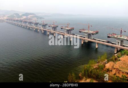 Zhengzhou. 9 avril 2020. La photo aérienne prise le 9 avril 2020 montre le chantier d'un pont de l'autoroute Mianchi-Yuanqu au-dessus de la rivière jaune, province du Henan au centre de la Chine. Le pont est une importante voie express interprovinciale reliant les provinces de Shanxi et de Henan, avec une longueur design de 1 757 mètres et une largeur de 33 mètres. Le projet devrait être achevé et ouvert au trafic d'ici la fin de 2020. Crédit: Zhu Xiang/Xinhua/Alay Live News Banque D'Images