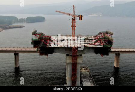 Zhengzhou. 9 avril 2020. La photo aérienne prise le 9 avril 2020 montre le chantier d'un pont de l'autoroute Mianchi-Yuanqu au-dessus de la rivière jaune, province du Henan au centre de la Chine. Le pont est une importante voie express interprovinciale reliant les provinces de Shanxi et de Henan, avec une longueur design de 1 757 mètres et une largeur de 33 mètres. Le projet devrait être achevé et ouvert au trafic d'ici la fin de 2020. Crédit: Zhu Xiang/Xinhua/Alay Live News Banque D'Images